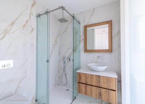 een badkamer met een glazen douche en een wastafel bij Casa Mango by ACasaDasCasas in Ericeira