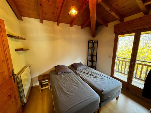 une chambre avec un lit dans une pièce avec une fenêtre dans l'établissement Appartement Saint-Gervais, à Saint-Gervais-les-Bains