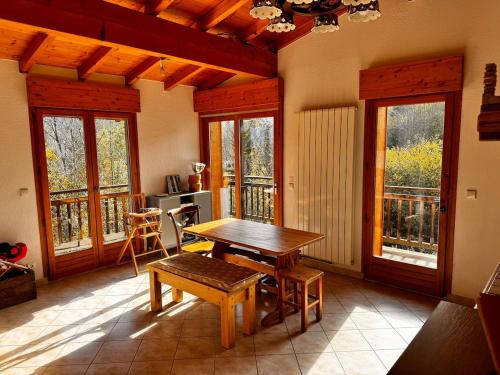 - un salon avec une table en bois et quelques fenêtres dans l'établissement Appartement Saint-Gervais, à Saint-Gervais-les-Bains