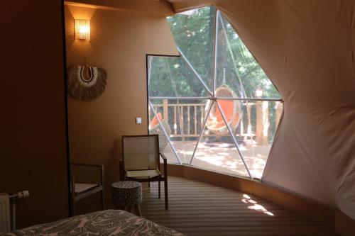 a room with a bed and a window with a balcony at Le Hameau Arribas in Condé-Sainte-Libiaire