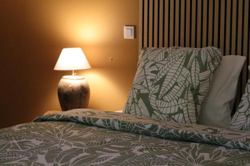 a bedroom with a bed with a lamp next to it at Le Hameau Arribas in Condé-Sainte-Libiaire