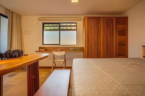 una camera da letto con un letto, una scrivania e una finestra di Arara house 4 a Jericoacoara