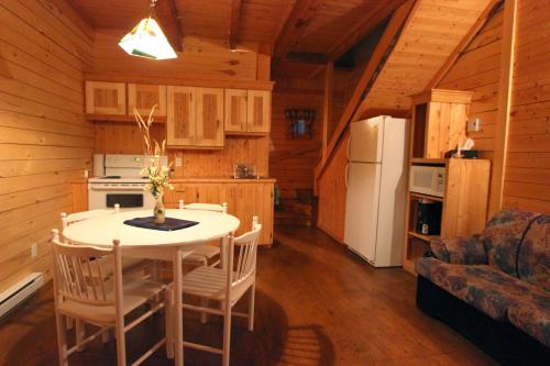 a kitchen with a table and chairs in a cabin at Chalets Nature Océan in Perce