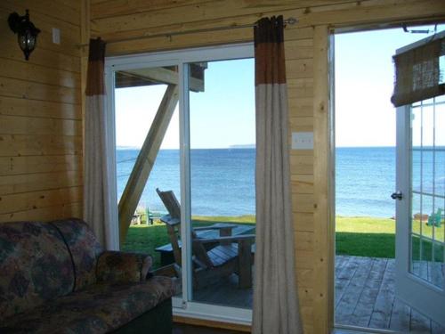 a living room with a view of the ocean at Chalets Nature Océan in Perce