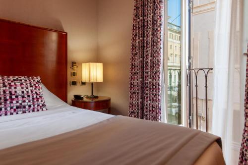 a bedroom with a bed and a large window at Hotel Delle Nazioni in Rome