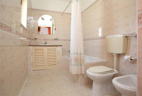 a bathroom with a toilet and a sink and a tub at Villa Da Duarte - walkable to beach shops bars in Albufeira