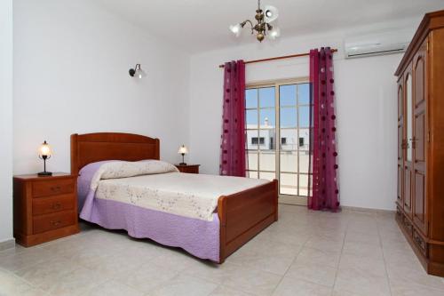 a bedroom with a bed and a large window at Villa Da Duarte - walkable to beach shops bars in Albufeira