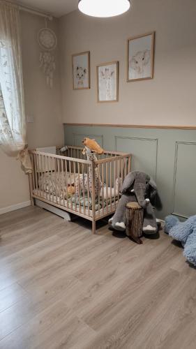 - une chambre bébé avec un berceau et des animaux farcis dans l'établissement Jolie villa paisible, à Montferrier-sur-Lez