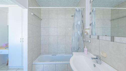 ストロイスバーイにあるBlue Whaleの浴槽、洗面台、シャワーを備えたバスルーム