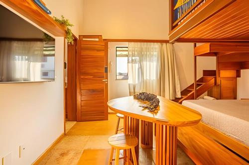 ジェリコアコアラにあるArara house 3のベッド、テーブル、二段ベッドが備わる客室です。