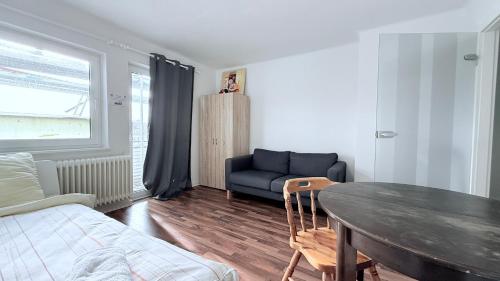 a living room with a table and a couch at Neumünster Apartments direkt an der Stadthalle mit WLAN & Parkplatz in Neumünster