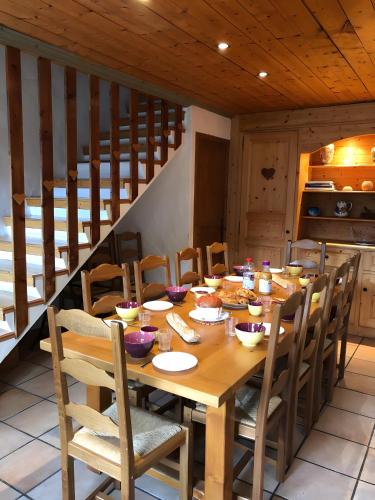 une table en bois dans une cuisine avec une table et des chaises dans l'établissement Chalet Juliette, à Champagny-en-Vanoise