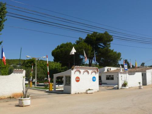 a small white building with flags on it at Parque de Campismo Orbitur Valverde in Luz