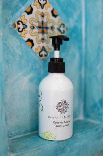 a white bottle of soap sitting on a blue table at Casa Paradis Boutique Hotel in Jambiani