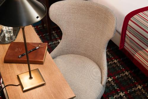 a lamp sitting on a table next to a chair at Les Tournelles in Paris