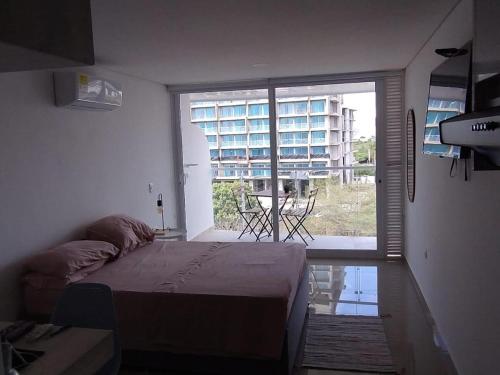 a bedroom with a bed and a large window at Aparta suite en Santa Marta in Santa Marta