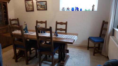 a dining room with a wooden table and chairs at Meadow View in Chalford