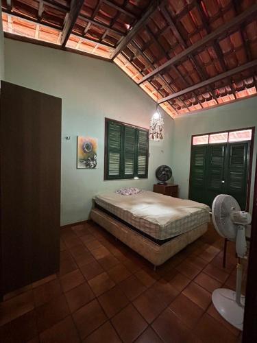 a bedroom with a bed and green shuttered windows at Casa acolhedora no Cumbuco in Caucaia