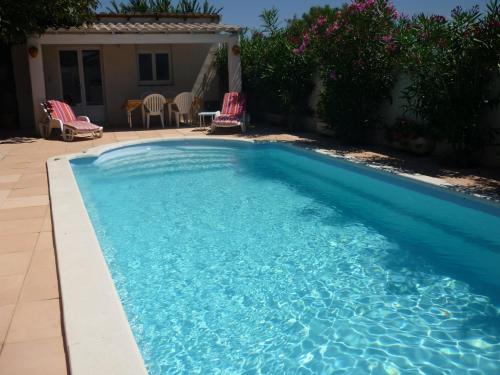 - une piscine d'eau bleue dans la cour dans l'établissement Soleil De Camargue, à Le Sambuc