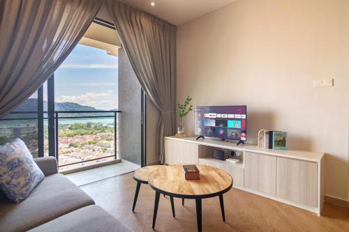 a living room with a couch and a table and a tv at Iconic Regency by Stellar ALV in Bayan Lepas