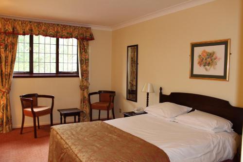 Un pat sau paturi într-o cameră la The Devil's Punchbowl Hotel