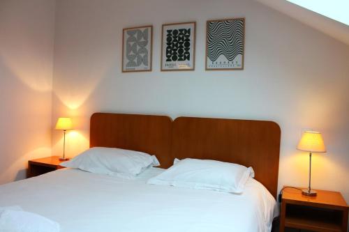 a bedroom with a bed with two lamps on tables at La Bullote - Gîtes - Paris Roissy CDG in Villeneuve-sous-Dammartin