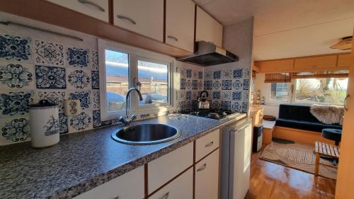 a kitchen with a sink and a window at City Farmer Farmyard Stays, Sleep Easy, Stay Rural, Explore Amsterdam in Amsterdam
