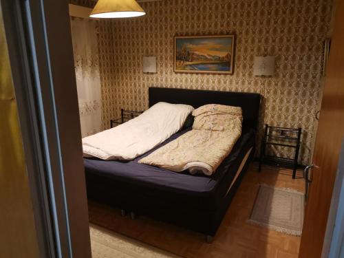 a small bed in a room with a picture on the wall at Talo Ristiinassa in Mikkeli
