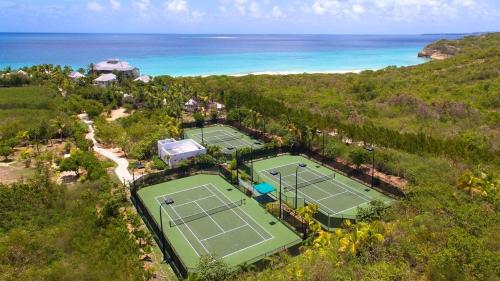 an aerial view of two tennis courts near the ocean at Blessed to Dream Villas in Long Bay Village