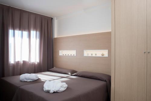 two beds in a bedroom with towels on them at Aparthotel Acualandia in Peñíscola