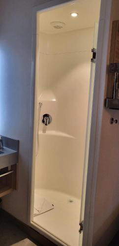 a shower in a bathroom with a sink at Ibis Budget Paris porte de la Chapelle - Aréna in Paris