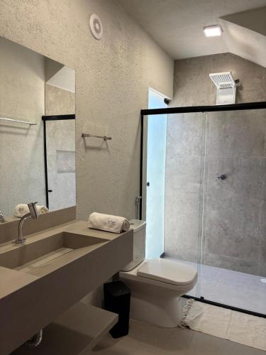 a bathroom with a sink and a toilet and a shower at Villa Aracê in São Miguel dos Milagres