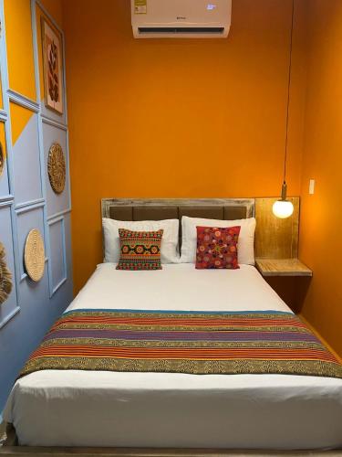 a bedroom with a bed with an orange wall at Coco Beach Cartagena in Cartagena de Indias