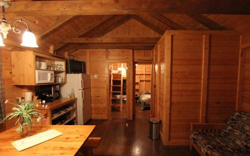 a kitchen with wooden walls and a table in a room at Chalets Nature Océan in Perce