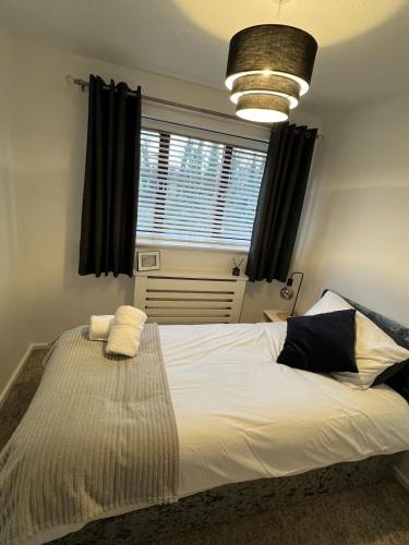 a bedroom with a large white bed with a window at Mill Croft, Home from Home in Bolton
