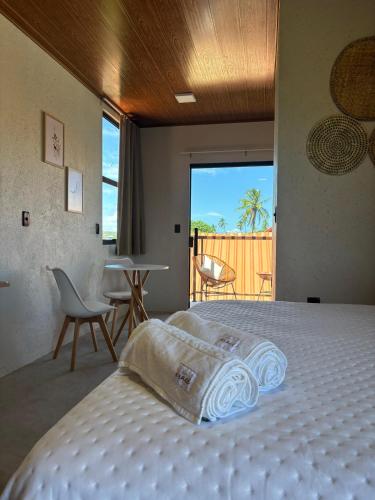 a bedroom with a bed with a view of the ocean at Villa Aracê in São Miguel dos Milagres