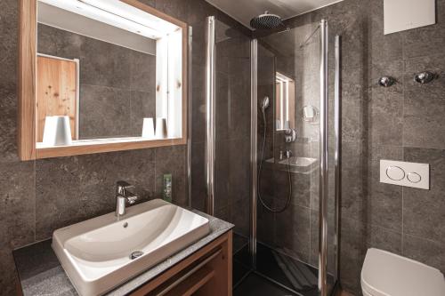 a bathroom with a sink and a shower at Brunnenhof Oberstdorf - Ferienwohnungen mit Hotel Service in Oberstdorf