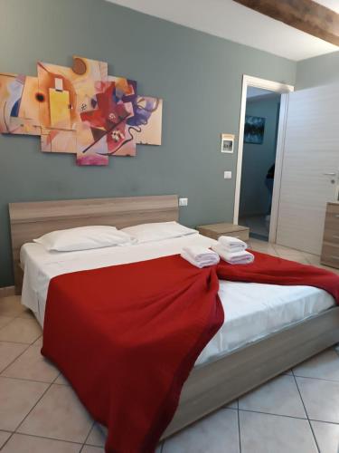 a bedroom with a bed with a red blanket on it at CAMERA EMILIA via emilia ovest 224 in Parma