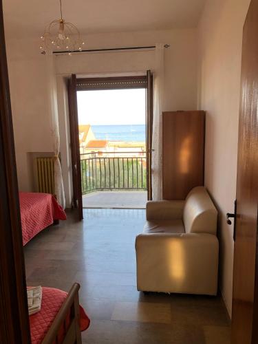 a living room with a chair and a door to a balcony at Ardor Domus in Ardore Marina