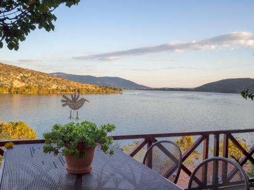 a table with a bird statue on a balcony overlooking a lake at Beautiful house with garden and amazing lake view in Kastoria