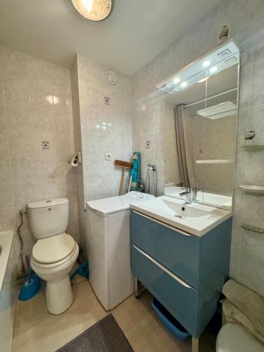 une salle de bain avec toilettes, lavabo et miroir dans l'établissement Appartement - Cap d'Agde, au Cap d'Agde