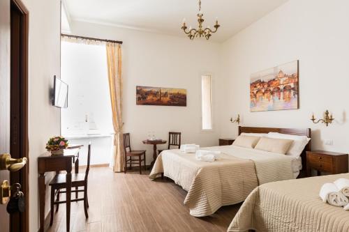 ローマにあるカーサ イン モンティのベッドルーム1室(ベッド2台、テーブル、椅子付)