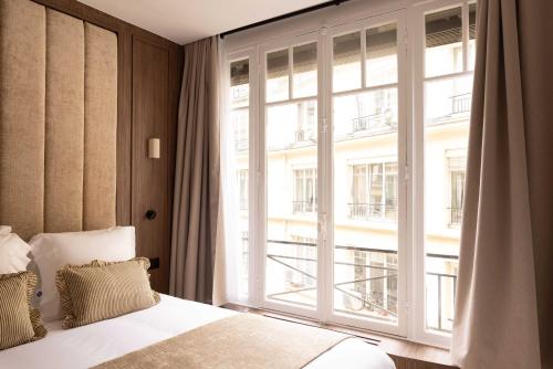 une chambre avec un lit et une grande fenêtre dans l'établissement Elegant apartment - AC- 2BR-6P- Madeleine, à Paris