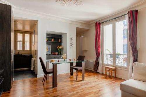 une salle à manger et un salon avec une table et des chaises dans l'établissement Paris Blomet Design Residence, à Paris