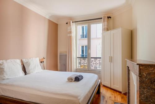 une chambre avec un lit blanc avec une fenêtre dans l'établissement Paris Blomet Design Residence, à Paris