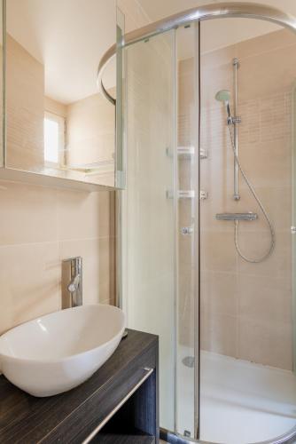 une salle de bain avec un lavabo et une douche dans l'établissement Paris Blomet Design Residence, à Paris
