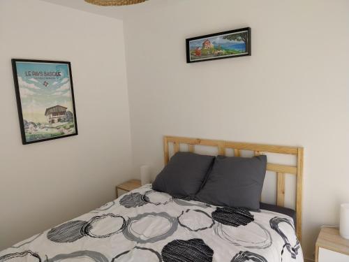 une chambre avec un lit et deux tableaux au mur dans l'établissement Etchehassia, à Cambo-les-Bains