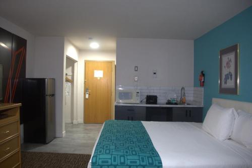 una camera da letto con un letto grande e una cucina di Howard Johnson by Wyndham Fort St. John a Fort St. John