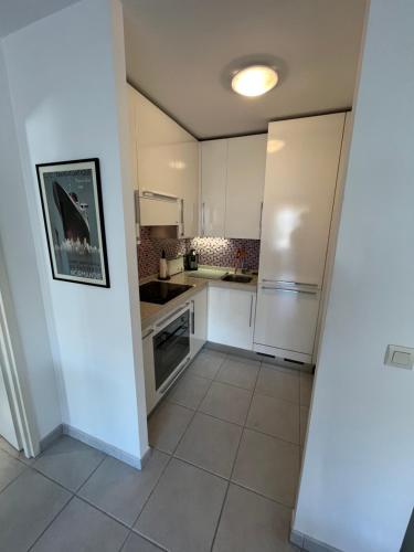 Il comprend une cuisine avec des appareils électroménagers blancs et du carrelage. dans l'établissement Nice Massena 2 rooms, à Nice