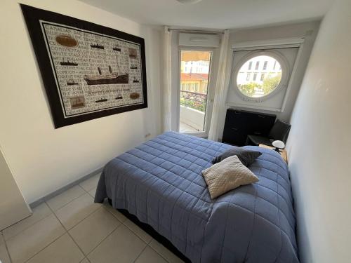 une chambre avec un lit bleu et une fenêtre dans l'établissement Nice Massena 2 rooms, à Nice